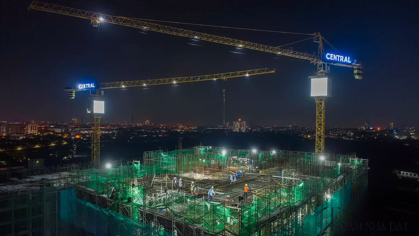 Ảnh ghép ba mốc công trường của một dự án chung cư cao tầng dọc Quốc lộ 13 khung hình đầu là tháng 7 năm 2025 với các tháp mới lên khoảng 8 đến 10 tầng, khung hình giữa là tháng 1 năm 2026 với nhiều tháp đạt khoảng 18 đến 24 tầng và cần cẩu hoạt động dày đặc, khung hình cuối là tháng 5 năm 2026 với một tháp đã cất nóc và các tháp khác tiếp tục thi công, góc chụp từ vị trí quan sát ngoài công trường, ánh sáng và biển báo công trình chân thực như ảnh khảo sát thực địa